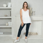 Woman wearing a white sleeveless tank and a navy tailored ankle length pant