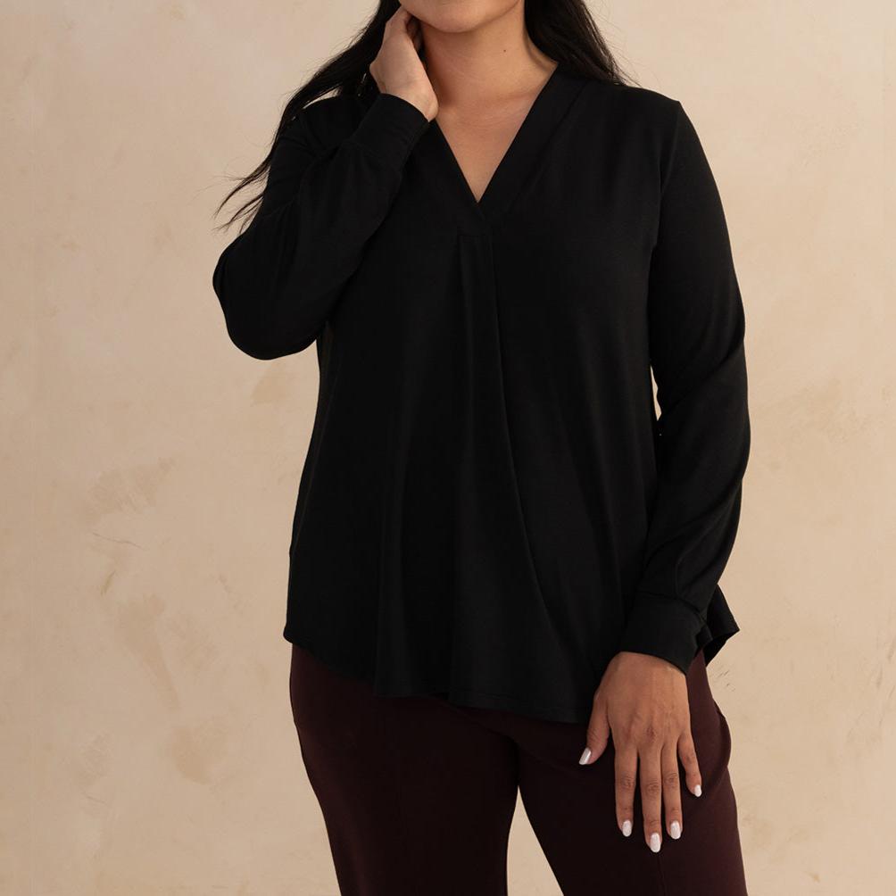 Woman wearing a loose flowing black v-neckline shirt 