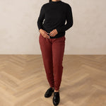 Woman wearing long sleeve black top with red relaxed pants