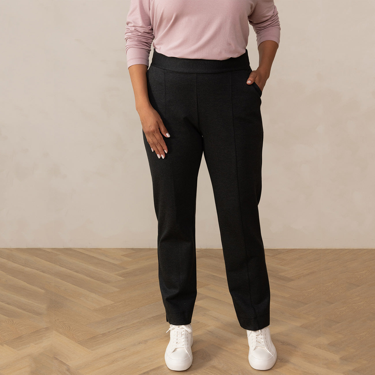 woman wearing a dark grey tailored pants with white sneakers