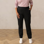 woman wearing a dark grey tailored pants with white sneakers