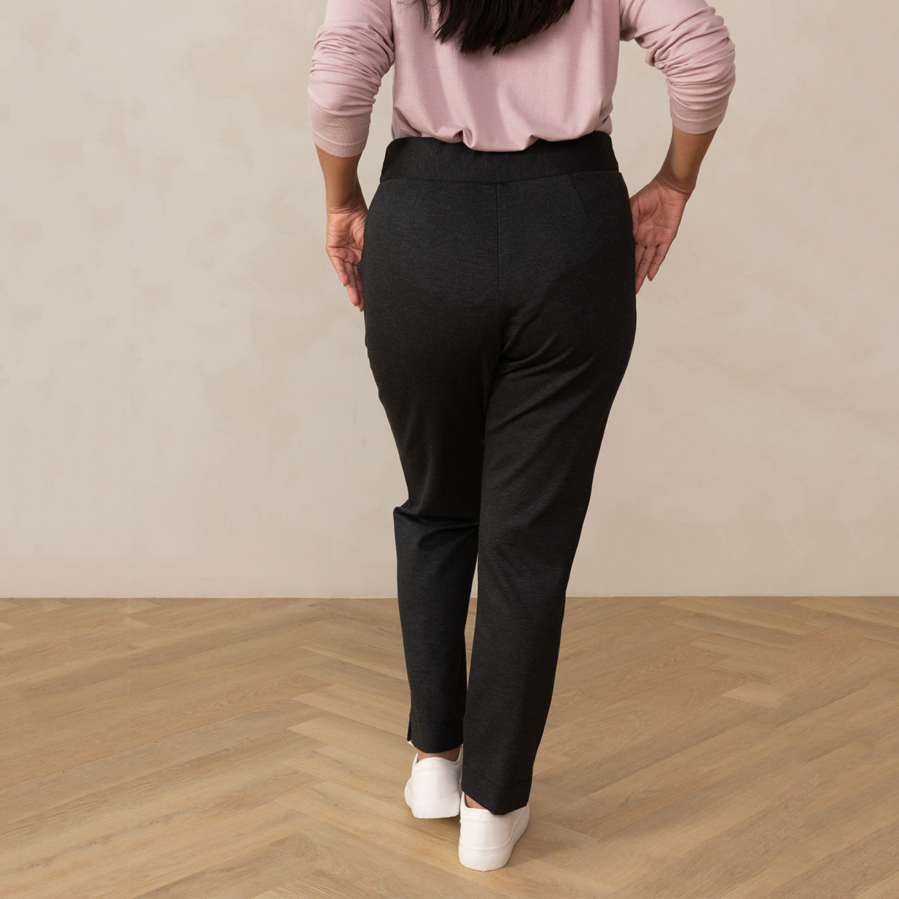 woman wearing a dark grey tailored pants with white sneakers