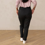woman wearing a dark grey tailored pants with white sneakers