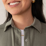 woman wearing a green button-up shirt on top of a white t-shirt
