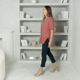 woman wearing a pink short sleeve t-shirt with ankle length navy tailored pants with two pockets