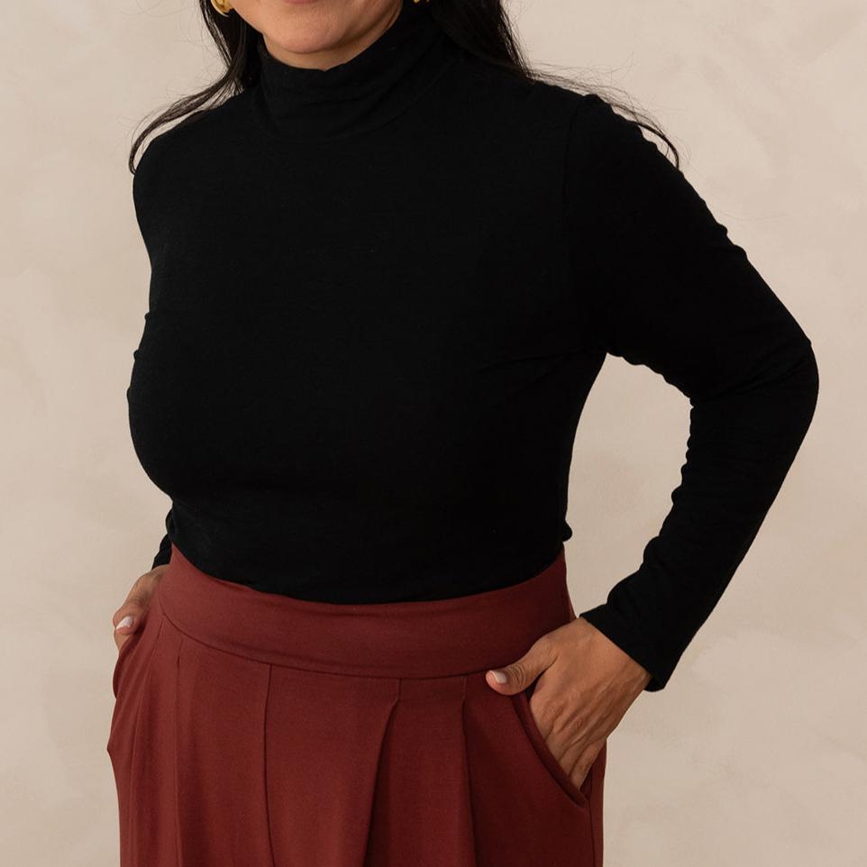 woman wearing a black turtleneck with brick colour pants