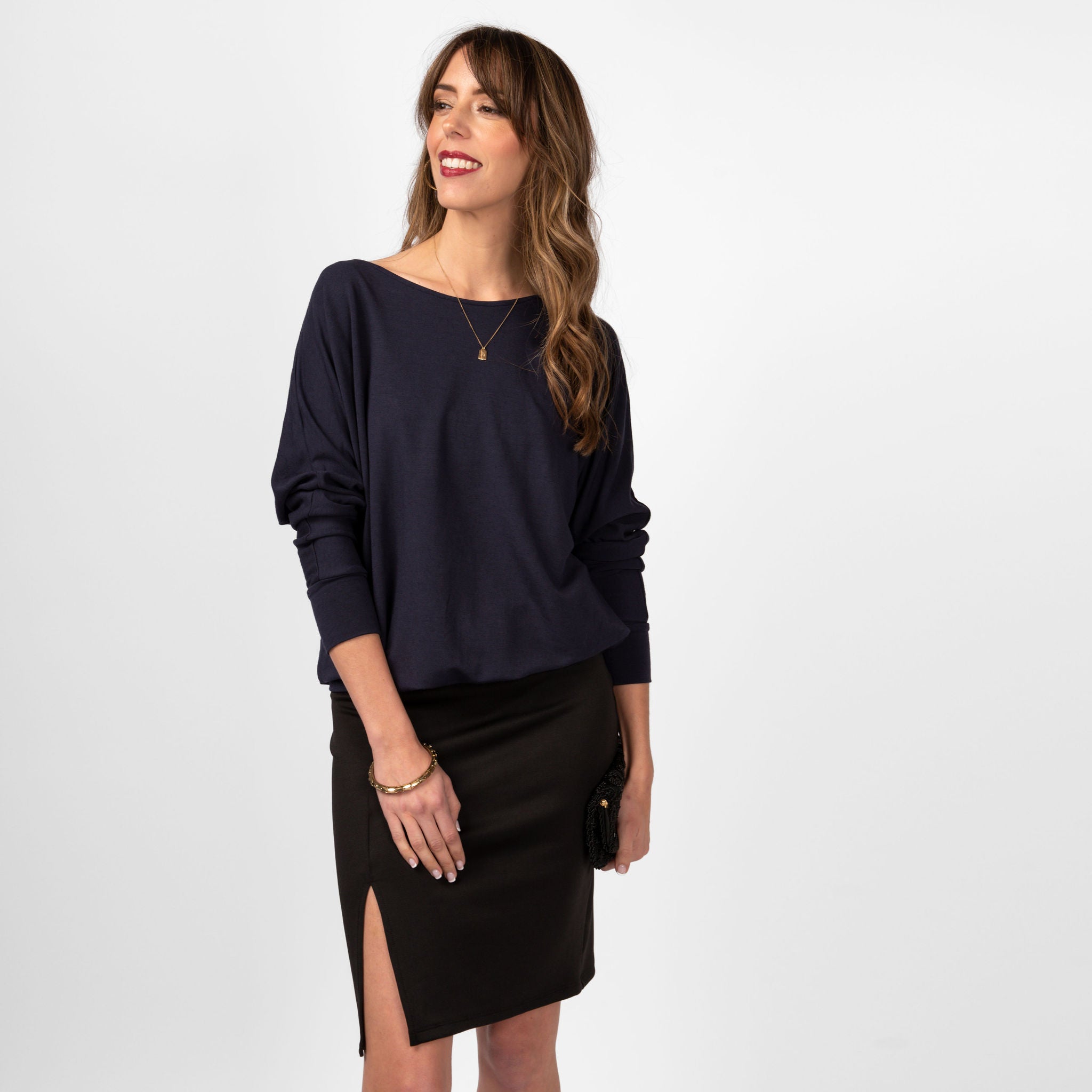 Woman wearing loose navy blue scoop neckline sweatshirt with black skirt